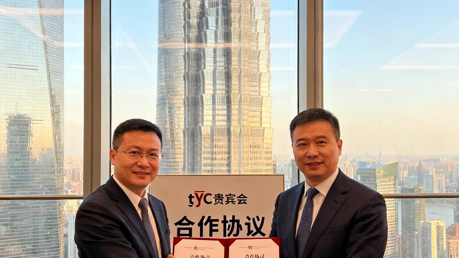 tyc贵宾会与上海陆家嘴某地标写字楼签署合作协议的现场照片，双方代表握手并展示签约文件